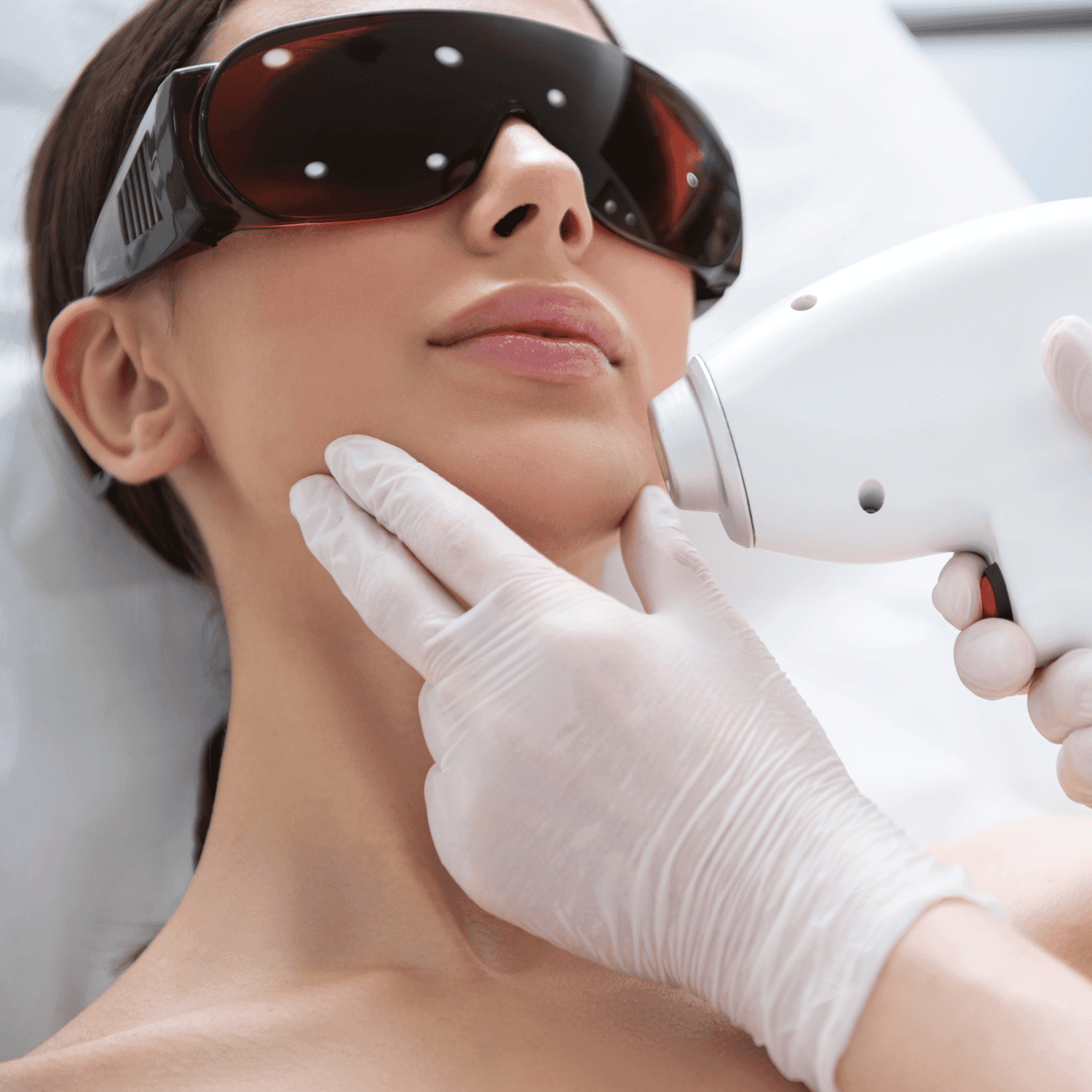 Laser hair removal treatment on woman's chin with protective eyewear.